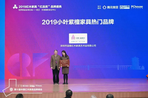 故宫博物院文保科技部原主任曹静楼（左）为“2019小叶紫檀家具热门品牌”获奖企业——泰和园颁奖
