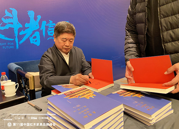 故宫学院院长单霁翔向红木家具企业代表赠书并合影，传递匠心精神