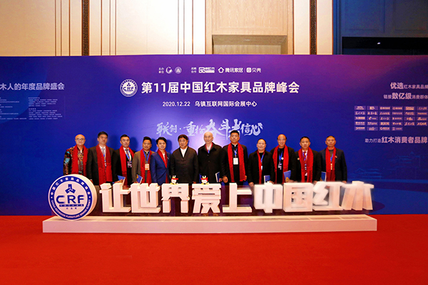 故宫学院院长单霁翔向红木家具企业代表赠书并合影，传递匠心精神
